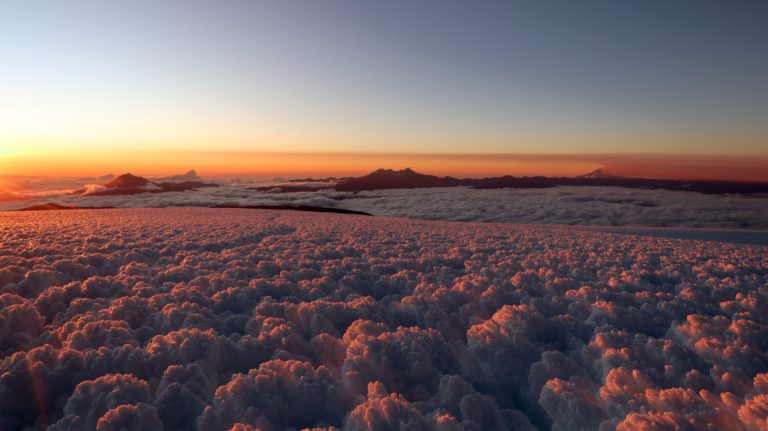 Der Sonnenaufgang taucht das Eis in rosa Licht.