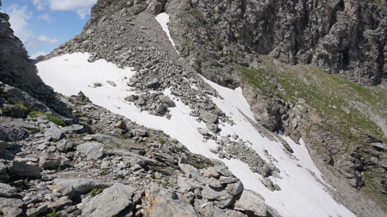 Steinhaufen leiten über den Felsriegel zur Kastellücke.