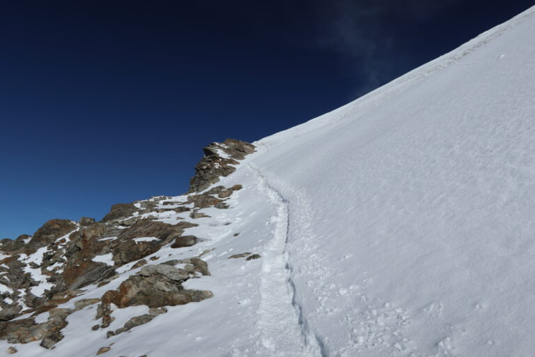 Querung unterhalb der Eisnase zu P. 4163. Der Felsrand schützt gut vor eventuellen Abstürzen.