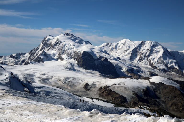 Blick zu Monte Rosa und Liskamm mit zwei Bergsteigern im Abstieg zur Eisnase