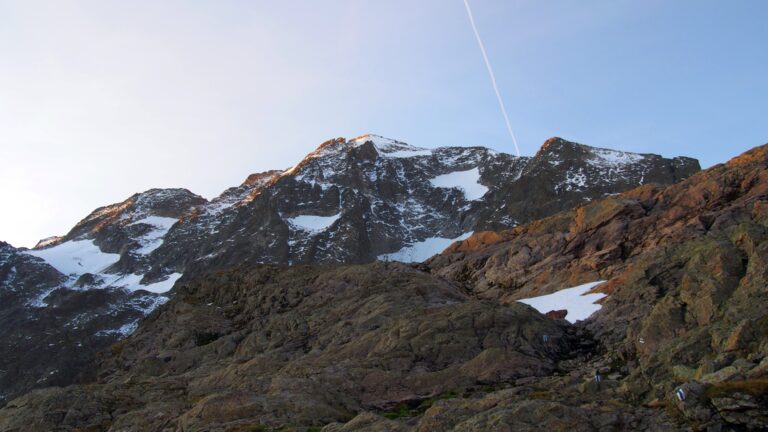 Die blau-weißen Markierungen leiten in der Morgendämmerung von der Kröntenhütte zum Graw Stock.