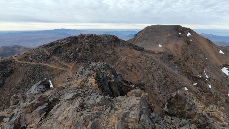 Blick vom Ras Ouanoukrim zum Timesguida hinten rechts im Bild, im Vordergrund mit Weg der südliche Vorgipfel